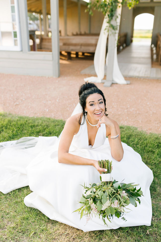 bride sitting and smiling on grass